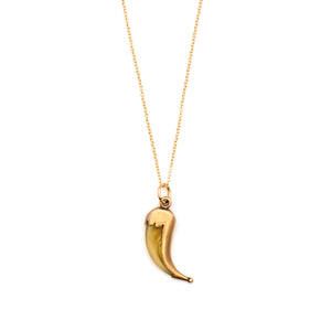 This unique horn charm features a polished 10k gold case, with a sculpted edge and a ball on the end. Cornetto in Italian means "little horn" and is an amulet or talisman that is believed to offer protection against the evil eye when worn. Paired with one of our new 14k gold chains, this statement making charm is believed to bring luck to whomever wears it. Front charm view, shown on chain