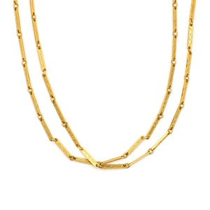 This 50" gold fill bar link chain is made up of delicate bar links, each intricately etched with an ornate, swirling design. Paired with one of our antique gold lockets or on its own, this chain makes for a delicate yet strong statement necklace. Close up view