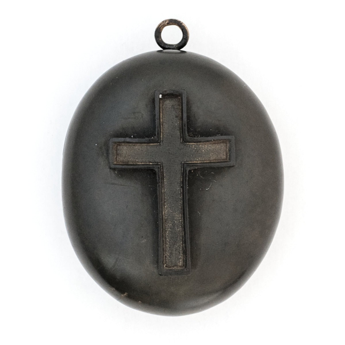 Gutta percha cross antique locket, front view, raised cross, black antique locket