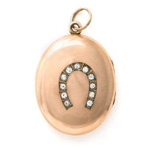 front view of oval horseshoe antique locket, gold fill locket with paste stones in horseshoe shape.