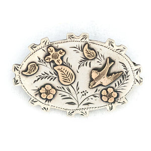 This stunning Victorian era pin is made of English sterling silver with 14K gold accents. It features classic Victorian symbols such as a swallow and forget-me-not flowers among other greenery. It is hallmarked for Birmingham, 1896. This beautiful artifact from the Victorian era will surely become an heirloom for a new generation. Front view of pin