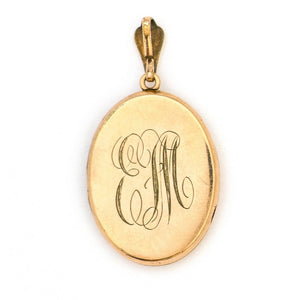 This oval locket features a white paste stone encrusted cross with a pinstripe backdrop. The letter EM are inscribed on the back. It opens to hold two photos, includes one original frame and pairs perfectly with one of our antique gold fill chains. Back Locket View