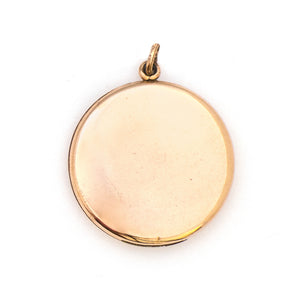 This round Victorian locket features a playful design which uses curlicues and flourishes to enhance the white and red paste stones. It opens to hold two photos, includes both original frames and pairs perfectly with one of our antique gold fill chains. Back locket view