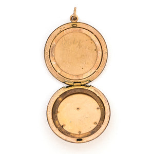 This round Victorian locket features a playful design which uses curlicues and flourishes to enhance the white and red paste stones. It opens to hold two photos, includes both original frames and pairs perfectly with one of our antique gold fill chains. Open locket view