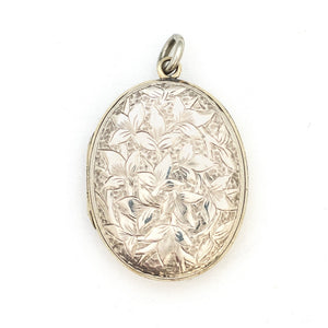 This sterling silver oval locket features a detailed garden vine pattern that covers the entire face of the locket. It opens to hold two photos, includes both original frames and pairs perfectly with one of our vintage sterling silver chains. Front Locket View