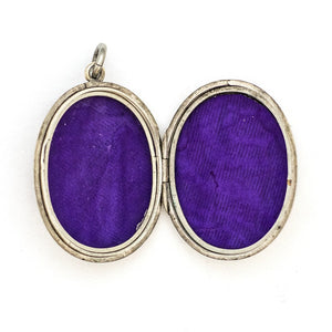 This sterling silver oval locket features a detailed garden vine pattern that covers the entire face of the locket. It opens to hold two photos, includes both original frames and pairs perfectly with one of our vintage sterling silver chains. Open locket view