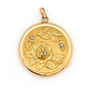This incredibly detailed round locket features a raised relief rose and branches with three white paste stones throughout the design. The letters JMR are inscribed on the back. It opens to hold two photos, includes one original frame and pairs perfectly with one of our antique gold fill chains. Front Locket View