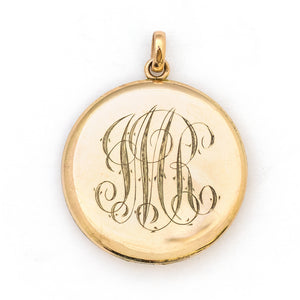 This incredibly detailed round locket features a raised relief rose and branches with three white paste stones throughout the design. The letters JMR are inscribed on the back. It opens to hold two photos, includes one original frame and pairs perfectly with one of our antique gold fill chains. Back Locket view