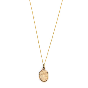 This petite oval 14K gold locket features a classic Victorian sparrow surrounded by carefully etched greenery on the front and back. It opens to hold two photos and pairs perfectly with one of our antique 14K gold chains. Front locket view, shown on chain