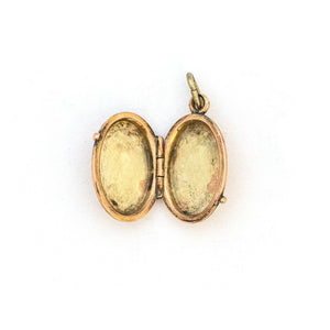 This petite oval 14K gold locket features a classic Victorian sparrow surrounded by carefully etched greenery on the front and back. It opens to hold two photos and pairs perfectly with one of our antique 14K gold chains. Open locket view