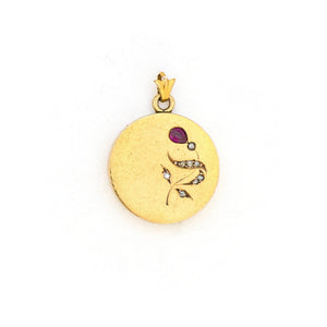 This petite 14K gold round locket features a whimsical floral design encrusted with 8 diamonds and a pear shaped ruby. It opens to hold two photos, includes one original frame and pairs perfectly with one of our antique 14K gold chains. Front Locket View