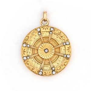 This striking round locket features an opal at it's center with intricate multi layered details and white paste stones radiating out in a sun-like pattern. It opens to hold two photos and pairs perfectly with one of our antique gold fill chains, front locket view