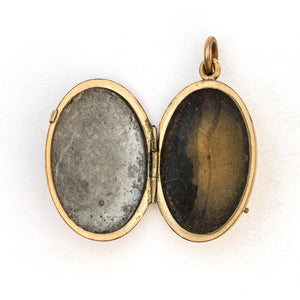 This oval locket features a gorgeous light blue and black enamel design with a finely textured background. It opens to hold two photos and pairs perfectly with one of our antique gold fill chains. Open Locket view