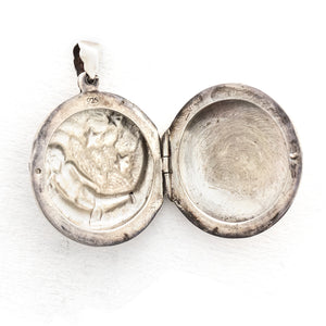 This round sterling silver Victorian locket features a woman lying in a crescent moon surrounded by stars. It opens to hold two photos and pairs perfectly with one of our antique sterling silver chains. Open locket view