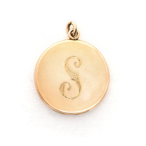 This round, matte locket features an ornate "S" in Victorian era script on the front and the initials MLC on the back. It opens to hold two photos, includes both original frames and pairs perfectly with one of our antique gold fill chains. Front view