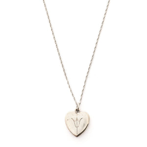 This heart shaped sterling silver locket features a simple and delicately etched tulip. The initials GFD are inscribed on the back. It opens to hold two photos, includes both original frames and pairs perfectly with one of our vintage sterling silver chains. Front locket view, shown on chain