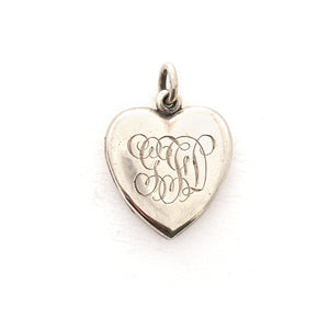 This heart shaped sterling silver locket features a simple and delicately etched tulip. The initials GFD are inscribed on the back. It opens to hold two photos, includes both original frames and pairs perfectly with one of our vintage sterling silver chains. Back locket view