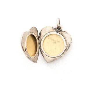 This heart shaped sterling silver locket features a simple and delicately etched tulip. The initials GFD are inscribed on the back. It opens to hold two photos, includes both original frames and pairs perfectly with one of our vintage sterling silver chains. Open locket view