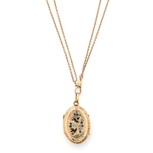 This striking oval locket features classic Victorian era symbolism with a pair of swallows surrounded by forget-me-not flowers enhanced with blue, white and green enamel throughout the design. It opens to hold two photos and pairs perfectly with one of our antique gold fill chains. Front Locket view, shown on chain