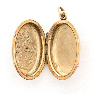 This striking oval locket features classic Victorian era symbolism with a pair of swallows surrounded by forget-me-not flowers enhanced with blue, white and green enamel throughout the design. It opens to hold two photos and pairs perfectly with one of our antique gold fill chains. Open Locket view