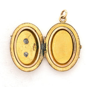 This oval locket features 5 pearls set above 8 turquoise baguettes with a zigzag pattern around the edge creating a dynamic three dimensional design. It opens to hold two photos, includes both original frames and pairs perfectly with one of our antique gold fill chains. Open locket view