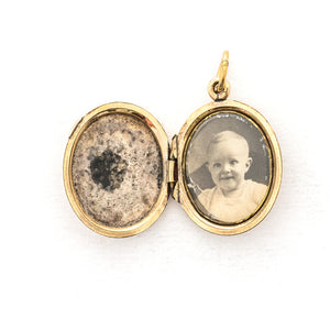 This sweet oval locket features a delicate rose design with navy blue enamel set on a finely textured background. The initials BBG are inscribed on the back. It opens to hold two photos, includes one original frame and glass and pairs perfectly with one of our antique gold fill chains. Open locket View