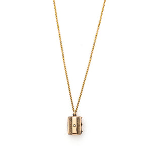 This petite rectangular locket features a basket weave pattern with a seed pearl on one side and a strip of black onyx on the other. It opens to hold two photos, includes both original frames and glass and pairs perfectly with one of our antique gold fill chains. Front Locket view, shown on chain