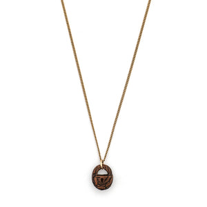 This unique lock charm is carved out of walnut wood and has intricate carving details along the surface and a "key hole." Paired with one of our vintage gold fill chains, this rare charm can be worn both as a alone as a pendant or in a cluster of charms. Front charm view, shown on chain