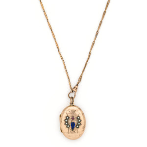 This unique oval Victorian locket features blue and red stones and seed pearls set within a finely etched bug design. It opens to hold one photo, and pairs perfectly with one of our antique gold fill chains. Front locket view, shown on chain