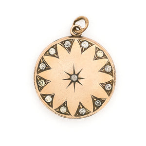 This round, matte locket features a starburst at the its center with a gorgeous border in Art Deco style and white paste stones throughout the design. It opens to hold one photo, includes one original frame and pairs perfectly with one of our antique gold fill chains. Front locket view