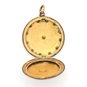 This round, matte locket features a starburst at the its center with a gorgeous border in Art Deco style and white paste stones throughout the design. It opens to hold one photo, includes one original frame and pairs perfectly with one of our antique gold fill chains. Open locket view