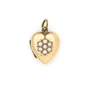 This sweet vintage heart-shaped locket features seven white glass stones in the shape of a snowflake with an intricate forget-me-not design on the back. It opens to hold one photo, includes one original frame and pairs perfectly with one of our antique gold fill chains. Front locket view
