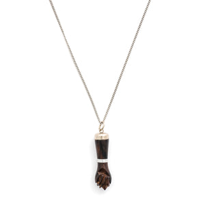 This unique figa hand charm is made of walnut wood and features sterling silver accents including the bail and a bracelet on the wrist. The figa symbol dates back to ancient times and in modern day is seen as a sign of female strength and empowerment. Paired with one of our antique sterling silver chains, this charm can be worn both as a pendant or in a cluster of charms. Charm on chain