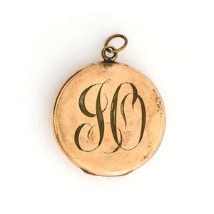 This Victorian round locket features a classic crescent moon and starburst, with a pearl encrusted crescent and jade as the center of the starburst. The letters "JO" are inscribed on the back. It opens to hold two photos and pairs perfectly with one of our antique gold fill chains. Back locket view