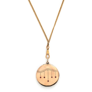 This striking round locket features red stones in a pleasing art deco style pattern. It opens to hold two photos and pairs perfectly with one of our antique gold fill chains. Front locket view shown on chain