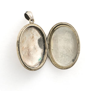 This large oval sterling silver locket features a finely etched swallow and bamboo scene, complete with rolling hills in the back drop. It opens to hold two photos and pairs perfectly with one of our antique sterling silver chains. Open locket view