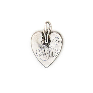 This heart charm is made of sterling silver and features a single blue cabochon stone inlaid in a star setting, and surrounded by a raised and textured border. The initials "AK" are finely etched on the back. Paired with one of our antique silver chains, this heart pendant can be worn both as a pendant or in a cluster of charms. Back charm view, monogram AK