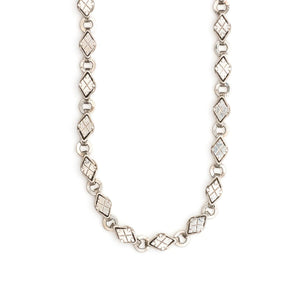 This Victorian-era chain is made of solid sterling silver and features intricately engraved horizontal diamond shapes interspersed with flat circular rings. Paired with a silver or silver and gold locket, this chain instantly makes a necklace more bold and eye-catching. Close up view showing links