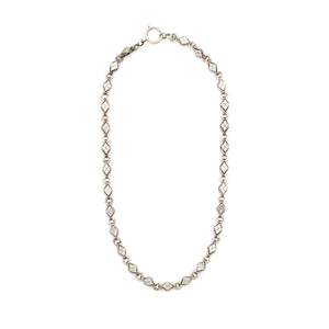 This Victorian-era chain is made of solid sterling silver and features intricately engraved horizontal diamond shapes interspersed with flat circular rings. Paired with a silver or silver and gold locket, this chain instantly makes a necklace more bold and eye-catching. Full chain view