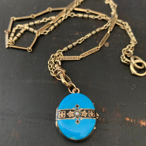 This 14k gold and black enamel bar link chain is made up of 2 watch chains which are both exquisitely etched with intricate black enamel patterns and compliment each other perfectly. Paired with one of our antique gold lockets or on its own, this chain will make a statement. Shown with blue enamel locket