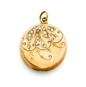 This joyous round locket features an intricate chandelier pattern with white paste stones scattered throughout the design. It opens to hold two photos, includes both original frames and pairs perfectly with one of our antique gold fill chains.  Front locket view