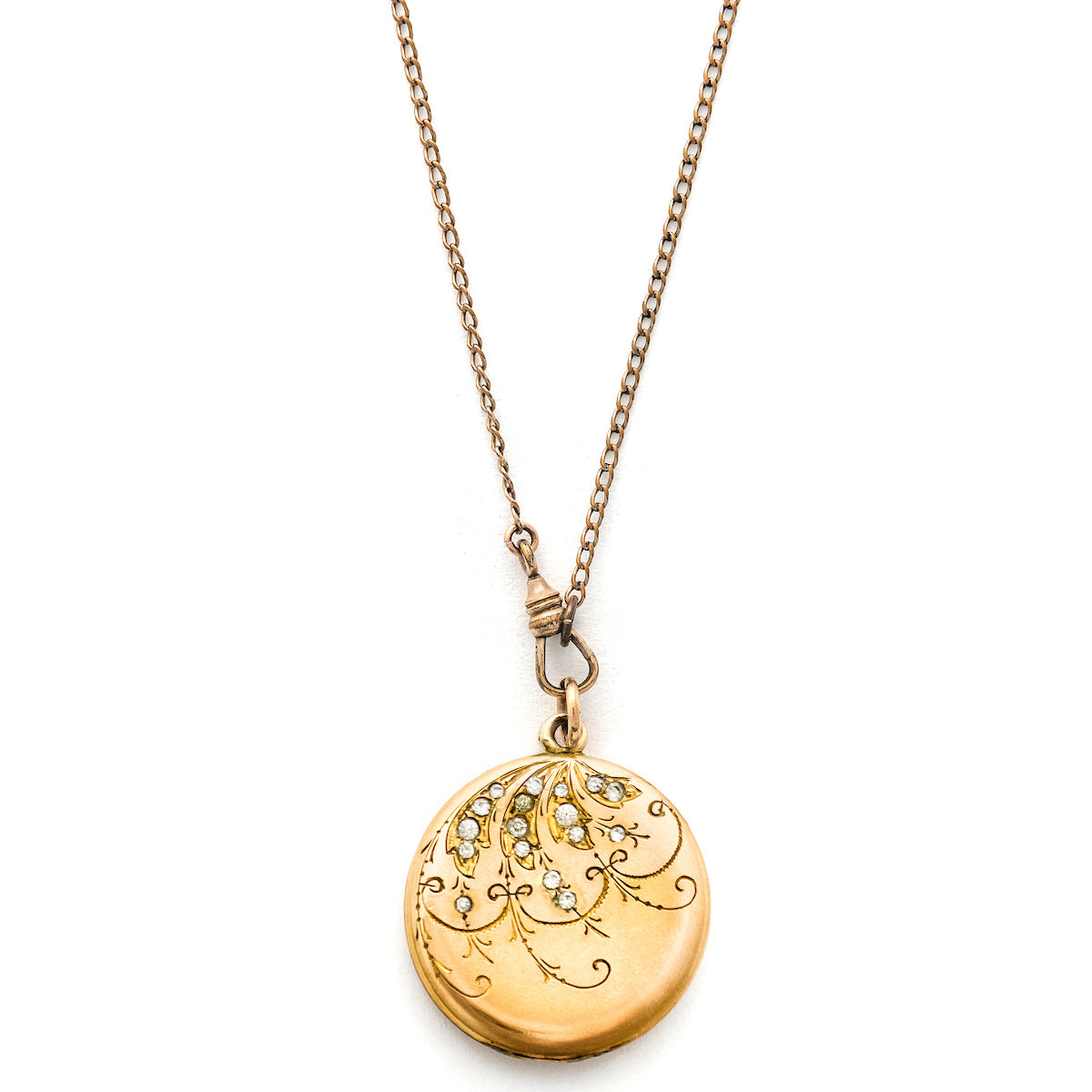 This joyous round locket features an intricate chandelier pattern with white paste stones scattered throughout the design. It opens to hold two photos, includes both original frames and pairs perfectly with one of our antique gold fill chains.  Front locket view