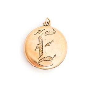 This round antique locket features a simple "E" in Old English script. It opens to hold two photos and pairs perfectly with one of our antique gold fill chains.  Front locket view
