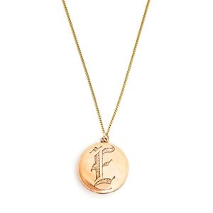 This round antique locket features a simple "E" in Old English script. It opens to hold two photos and pairs perfectly with one of our antique gold fill chains.  Front locket view shown on chain