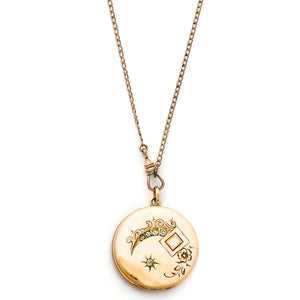 This glossy round locket features a classic Victorian era symbol, the crescent moon and starburst, but with exciting additional accents and flourishes including a forget-me-not flower. It opens to hold two photos, includes both original frames and pairs perfectly with one of our antique gold fill chains.  Front locket view, shown on chain