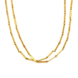 This 50" gold fill bar link chain is made up of delicate bar links, each intricately etched with an ornate, swirling design. Paired with one of our antique gold lockets or on its own, this chain makes for a delicate yet strong statement necklace. Close up view