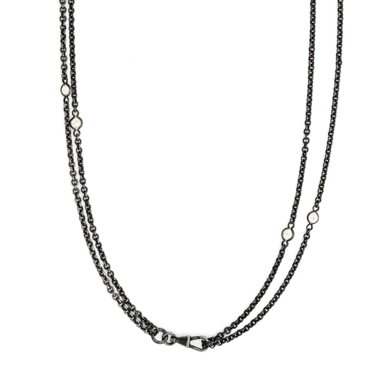This long Victorian gunmetal chain measures 52" in length and features 10 incredibly cut glass stones. Doubled up on a watch chain clasp, it is nearly 26" in length and is unique on its own or pairs perfectly with one of our vintage lockets. Close up view
