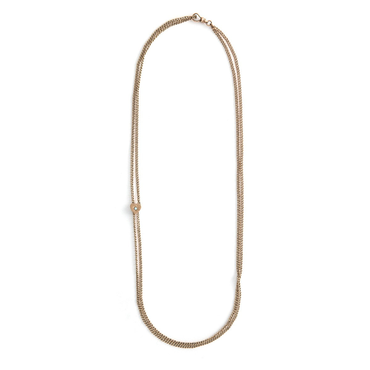 This 12K gold fill antique curb watch chain measures 25" in length doubled.  It features a gold fill heart shaped slide adornment with an etched flower with  an opal at its center. Doubled up, this chain is striking with a gold locket or on its own. Close up view showing heart opal slide