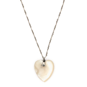 This sweet heart shaped Victorian mother of pearl pendant is beautifully iridescent and features a sterling silver bail. Paired with one of our antique silver chains, this charm can be worn both as a pendant or in a cluster of charms.  Front charm view, shown on chain