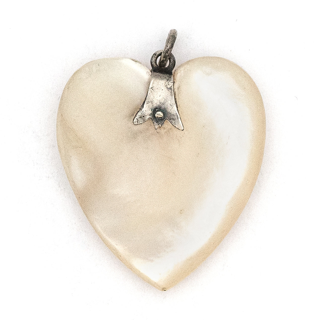 This sweet heart shaped Victorian mother of pearl pendant is beautifully iridescent and features a sterling silver bail. Paired with one of our antique silver chains, this charm can be worn both as a pendant or in a cluster of charms.  Front charm view